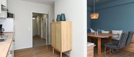 Una cocina moderna con microondas, armarios y un comedor con mesa y sillas.
