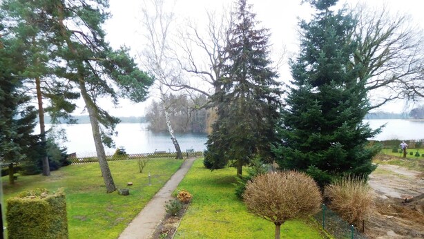A park with a walking path, trees, and a lake. - Summer house, rowing boat incl. - Summer house (Krakow am See)