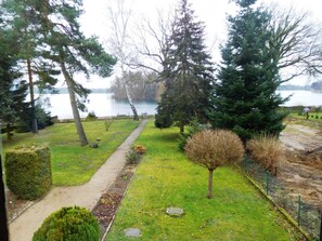 A park with a walking path, trees, and a lake. - Summer house, rowing boat incl. - Summer house (Krakow am See)