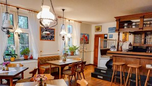 A cozy kitchen with wooden furniture, a dining area, and a bar. - Double room 3 - Rankwitzer Hof (Rankwitz)