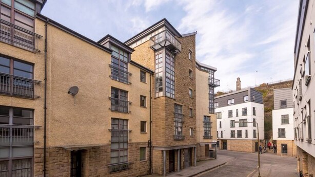 A street view of a row of modern buildings with balconies and large windows. - Old Town Flat with Parking near Royal Mile (Edinburgh)