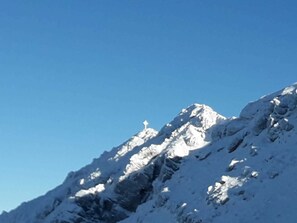 Un sommet montagneux enneigé sous un ciel bleu dégagé.