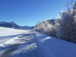 Uma estrada coberta de neve com montanhas ao fundo.