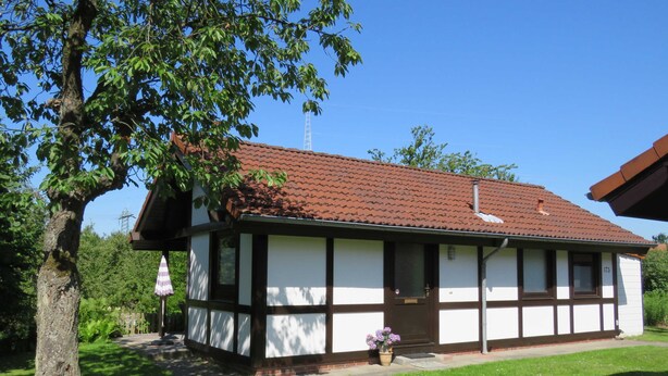 A traditional house with a tiled roof, a front porch, and a small garden area. - Vacation home 175 Mohikaner 40qm up to 5 persons with pet - Ferienhaus Mohikaner (Hollern-Twielenfleth)
