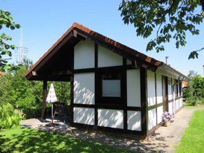 A small, single-story building with a sloped roof and a covered porch area.