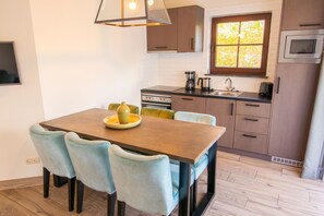 A modern kitchen with a dining table, chairs, and a window.