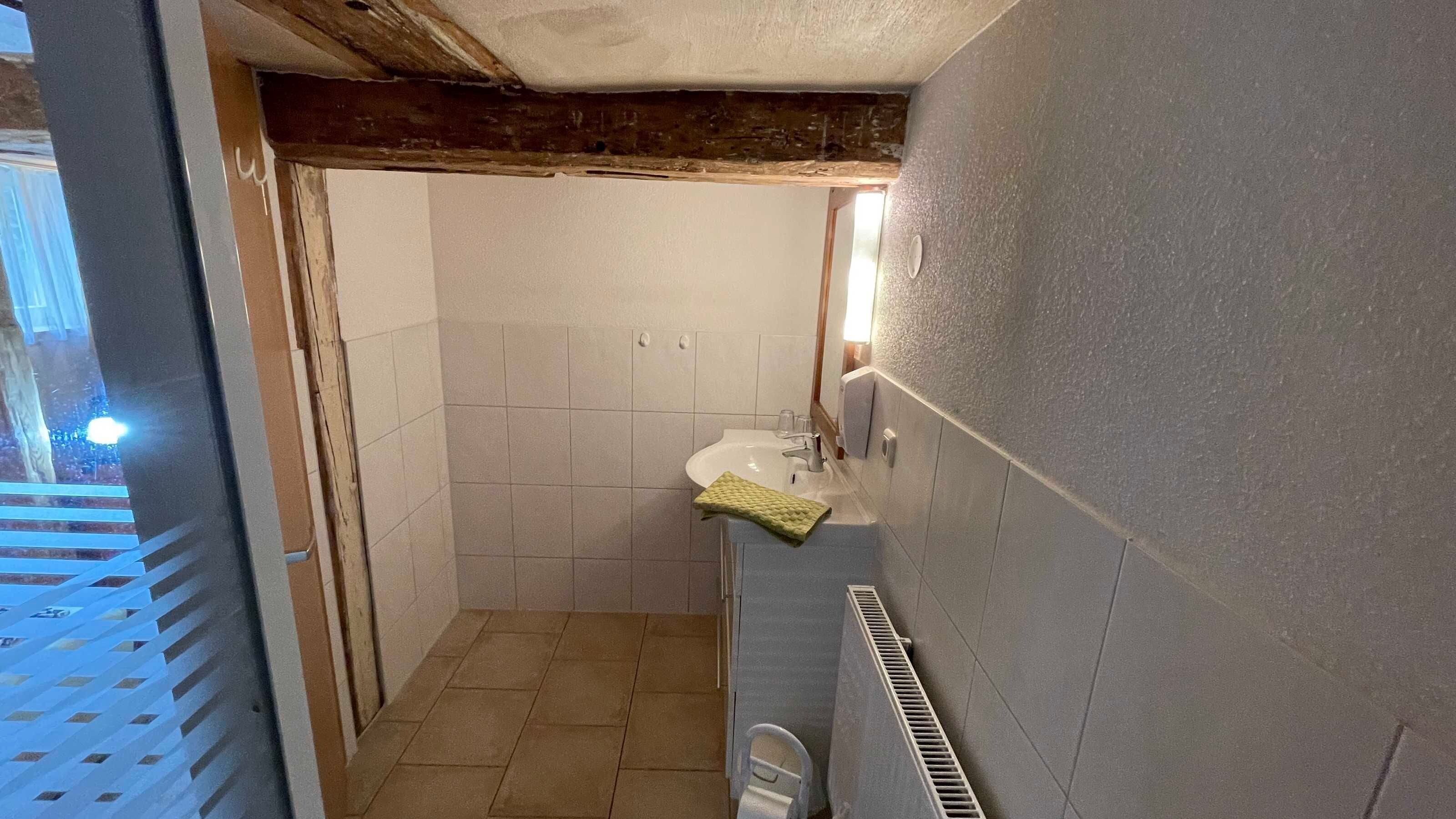 Ein Badezimmer mit Waschbecken, Spiegel und gefliesten Wänden.