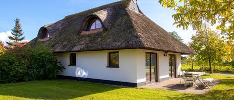 A house with a thatched roof, a small window, and a door.