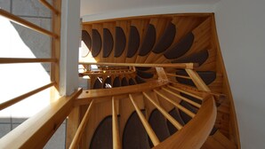 Una escalera de caracol con barandillas de madera y una serie de aberturas circulares.