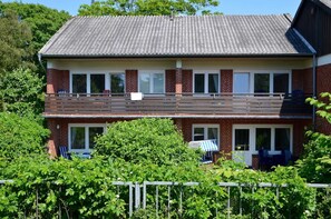 Un bâtiment à deux étages, doté d’un toit plat, de murs en briques et d’un balcon.