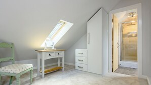 Et børneværelse med skrivebord, stol og et garderobeskab.