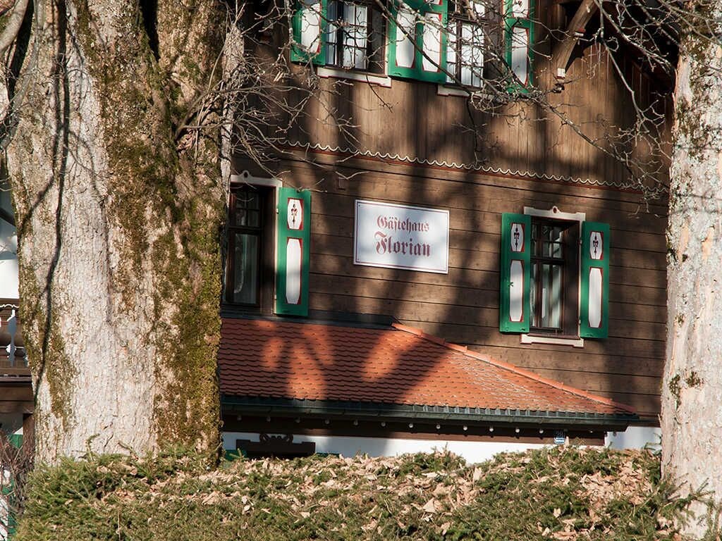 A traditional building with a sign reading 'Gästehaus Florian' and green window shutters.