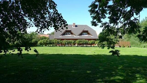 A house with a sloped roof, a front porch, and a well-maintained lawn.