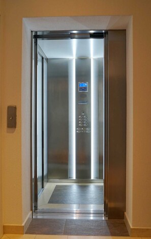 Un ascenseur doté d’un écran numérique, d’un panneau de commande et d’un intérieur métallique.
