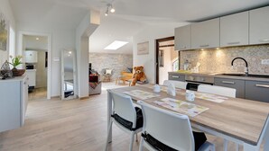 Una cocina moderna con comedor, que incluye una mesa grande, sillas y un oso de peluche.