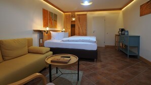 Un dormitorio acogedor con cama, sofá, una mesita y un armario.