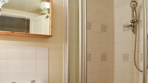 Une salle de bain avec un lavabo, un miroir et une douche.