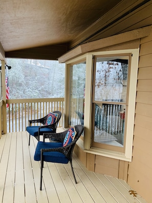 Relax on the covered porch with two comfortable chairs and a stunning view of the snow-covered landscape.