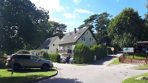 Una calle residencial con casas, coches aparcados y cielo despejado.