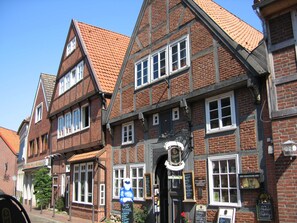 Un bâtiment traditionnel à colombages, doté de nombreuses fenêtres, d’une enseigne et d’une entrée bien visible.