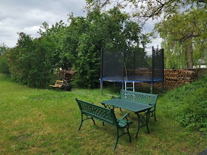 A grassy outdoor area with a trampoline, a bench, and a table. - Sleeping in the hay / hay bed - Ferienhof Sarodnick (Lauta)