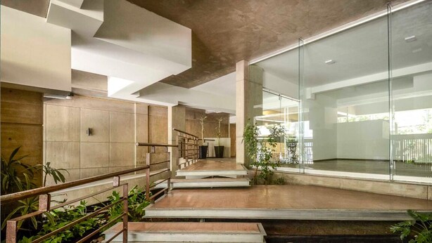Ein modernes Interieur mit einer Holztreppe, Glaswänden und einem minimalistischen Design.