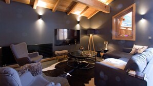 A modern living room with a fireplace, a TV, and a cozy seating area. - Super endroit ! Chalet montagnard avec sauna (L'Alpe d'Huez)