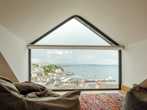 A room with a large window overlooking a marina and town. - 3 bedroom accommodation in Brixham (Brixham)
