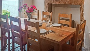 A dining table with chairs, a vase with flowers, and a star decoration on the wall. - 4 bedroom accommodation in Keswick (Keswick)