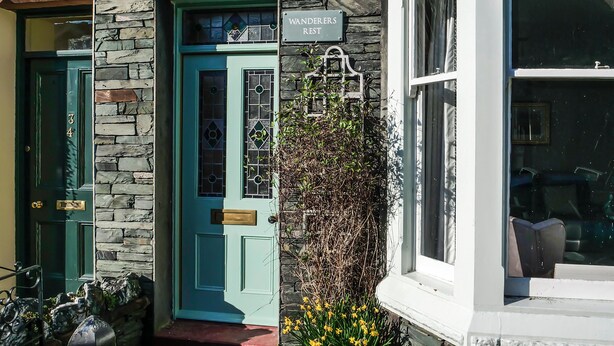 A building with a stone facade, a teal door, and a sign reading "WANDERERS REST". - 4 bedroom accommodation in Keswick (Keswick)