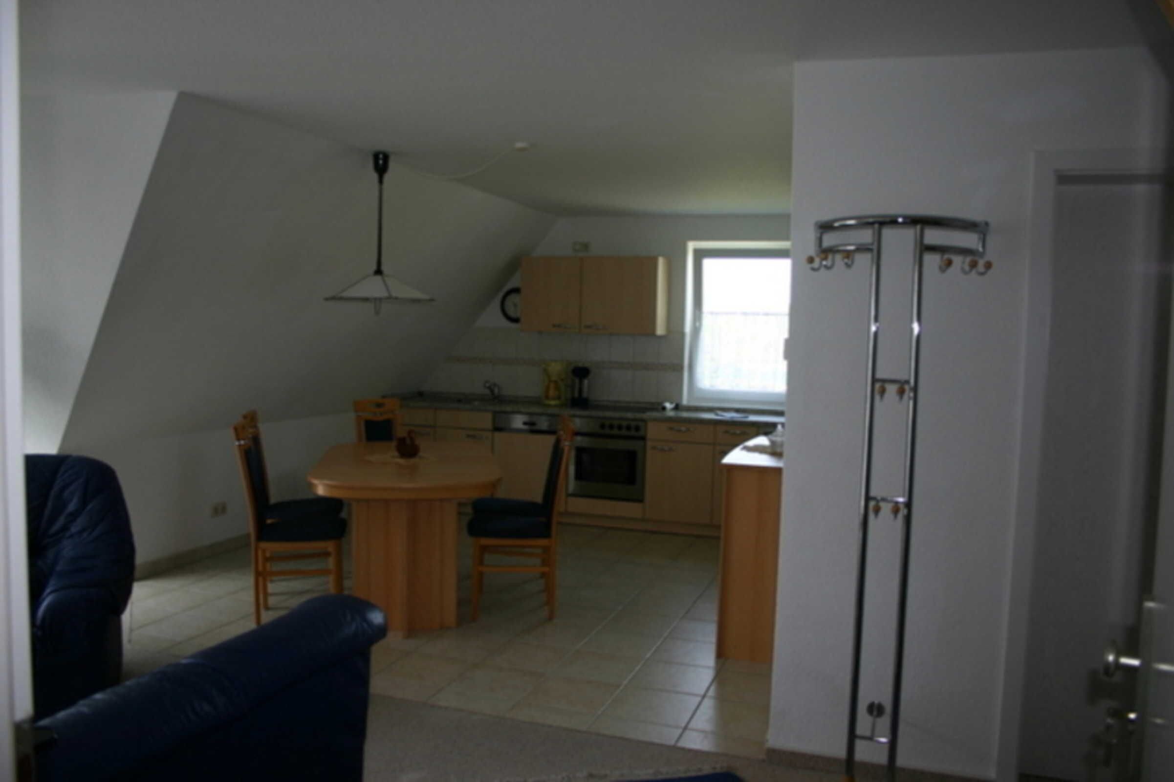 Eine kompakte Küche mit Essbereich, Deckenventilator und Fenster.