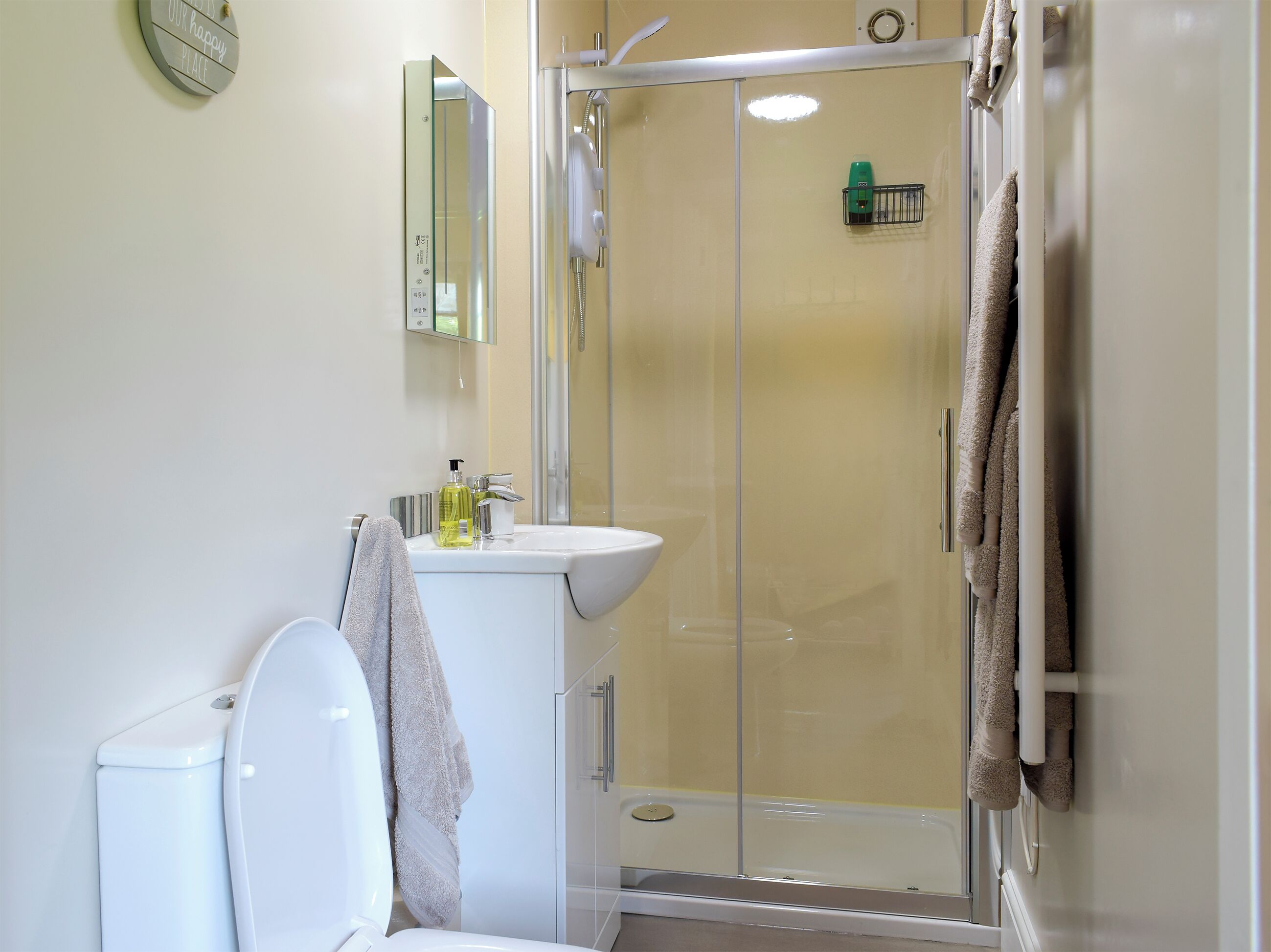 A modern bathroom with a toilet, sink, and glass-enclosed shower.