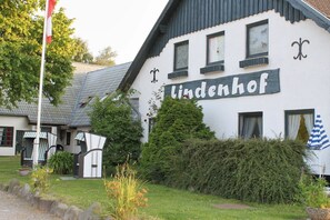 Un bâtiment sur lequel on peut lire l’inscription « Lindenhof », et un mât sur lequel flotte un drapeau.