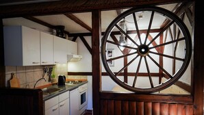 Una cocina con armarios blancos, un tragaluz de madera y techo de madera.