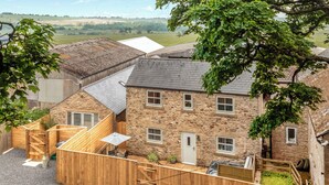 A stone house with a wooden deck and a view of the countryside. - Bullions Farm Cottage (Consett)