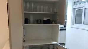 Una cocina con armarios blancos, una ventana y una puerta.