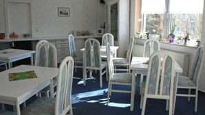 A room with white furniture, a window with plants, and a radiator. - 06 Single Room - Villa in the Baltic Sea resort Baabe (Baabe)