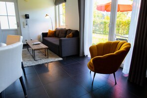 Una sala de estar moderna con un sofá, un sillón y una mesa de centro.