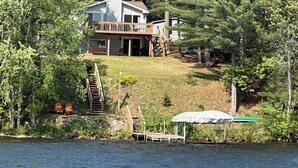 A lakeside cabin with a deck, surrounded by dense forest. - Sunset Pines Retreat Castle Rock Lake (Arkdale)
