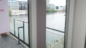 A view from a window overlooking a river with buildings and a bridge in the background. - Grand Canal Dock Waterfront Luxury “Special Offer” (Dublin)