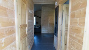 A wooden hallway with a tiled floor leading to a bedroom with a bed and a window. - Vacation home 4 Nordland 60sqm for max. 4 persons - Holiday home Nordland in the (Hollern-Twielenfleth)