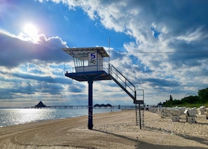 Une tour de surveillance avec le numéro 5, une plage et une jetée en arrière-plan.