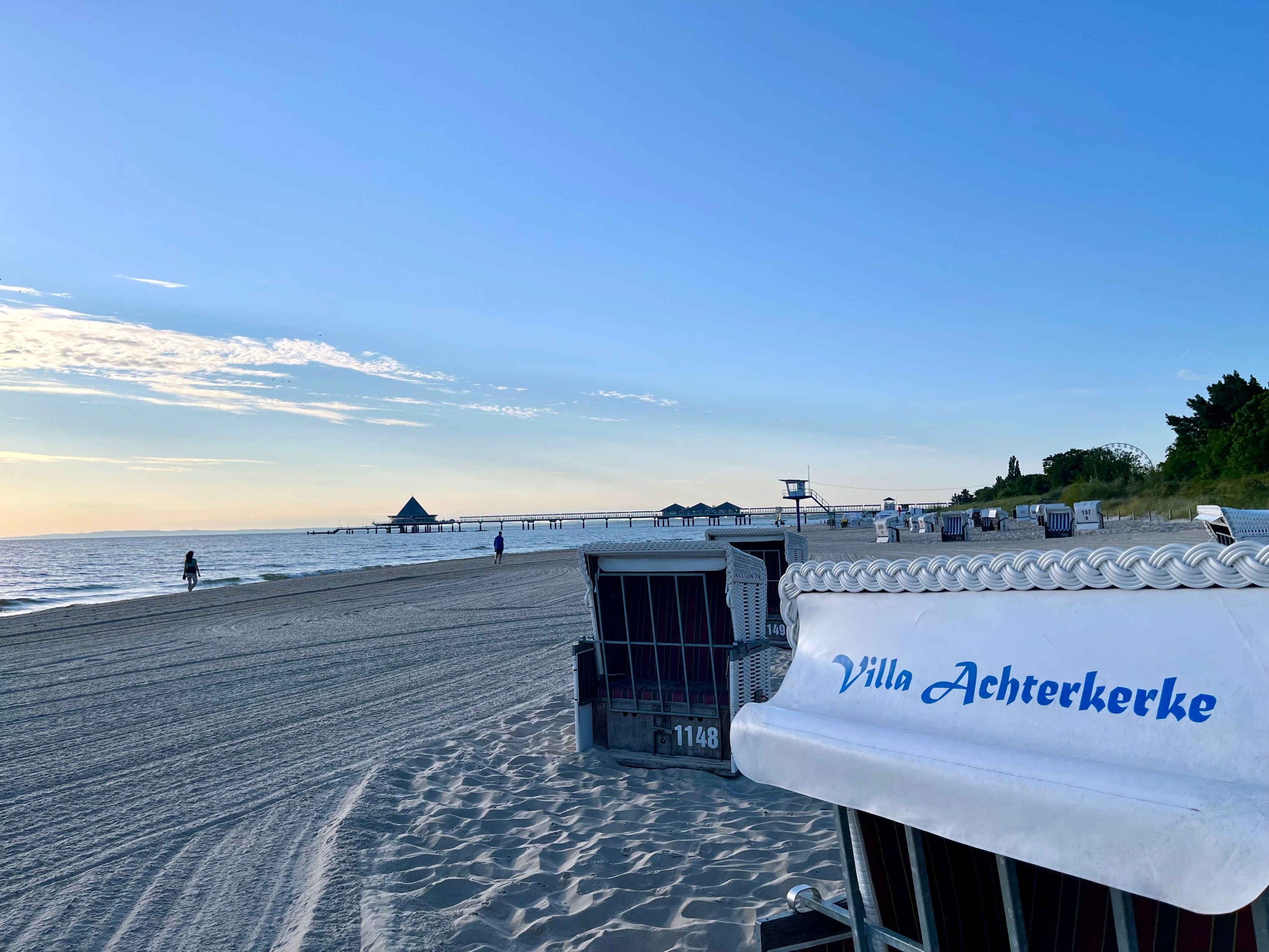 A beach view with a lifeguard tower, beach chairs, and a tent labeled 'Villa Achterkerke.'