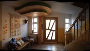 A room with a wooden bench, a desk, and a large window with a view. - Room 5 - House by the forest (Lichtenfels)
