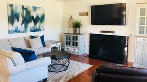 Ein Wohnzimmer mit einer Couch, einem Couchtisch und einem Flachbildfernseher.