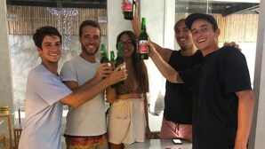 A group of people in a modern, well-lit room with a glass partition, wooden furniture, and a small table. - Stellar Capsules - Hostel (Seminyak)
