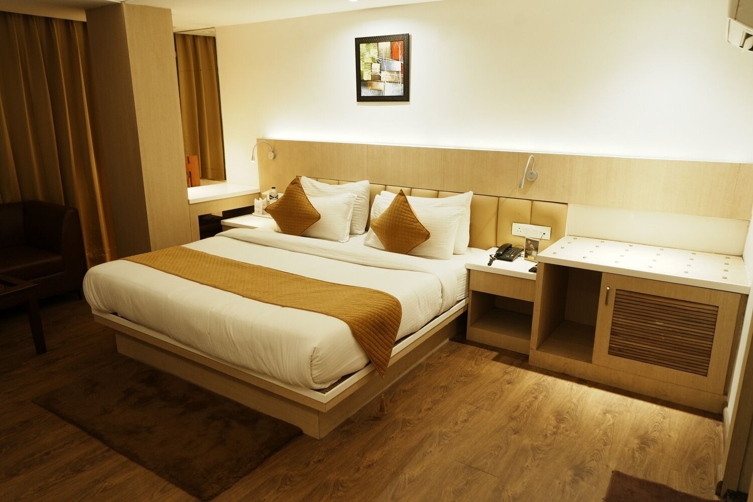 A hotel room with a large bed, bedside tables, a desk, and a chair.