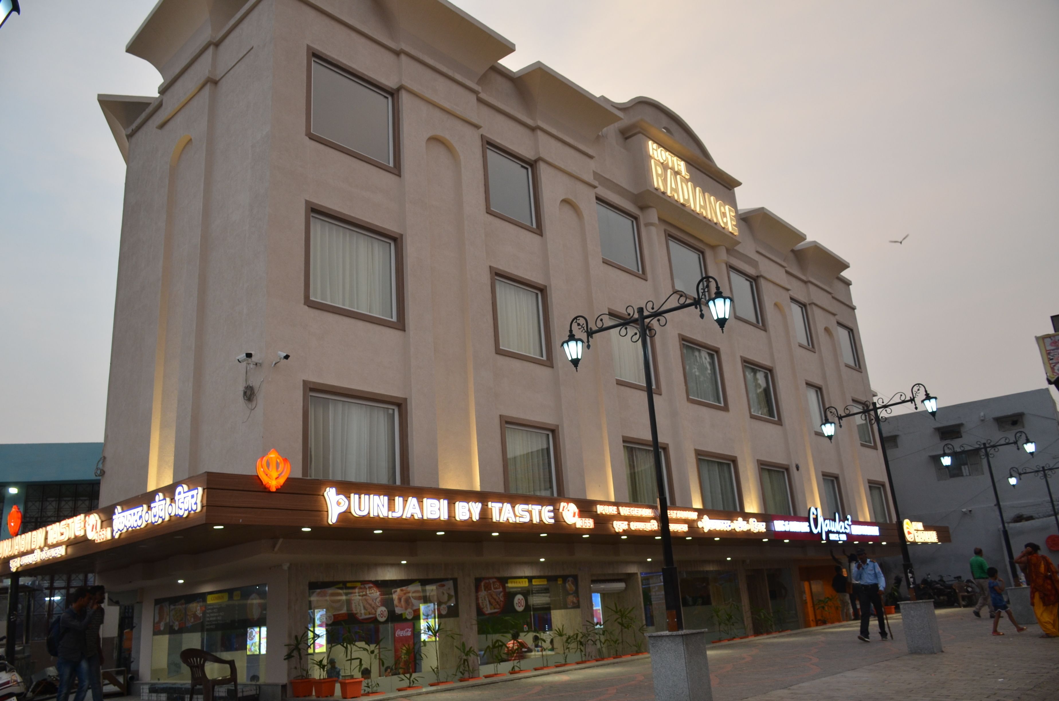 A hotel with a sign reading "Hotel Ramble" and another sign for "Punjabi by Taste."