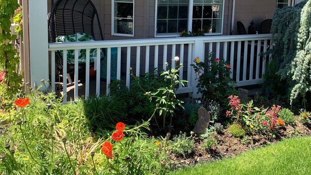 A house with a porch, a hanging chair, and a garden with various plants and flowers. - Luxury open concept Vacation Home. Close to downtown ,Old Mill trails & parks. (Bend)