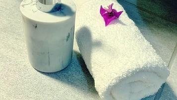 Un baño con una toalla blanca y un dispensador de jabón con bomba.